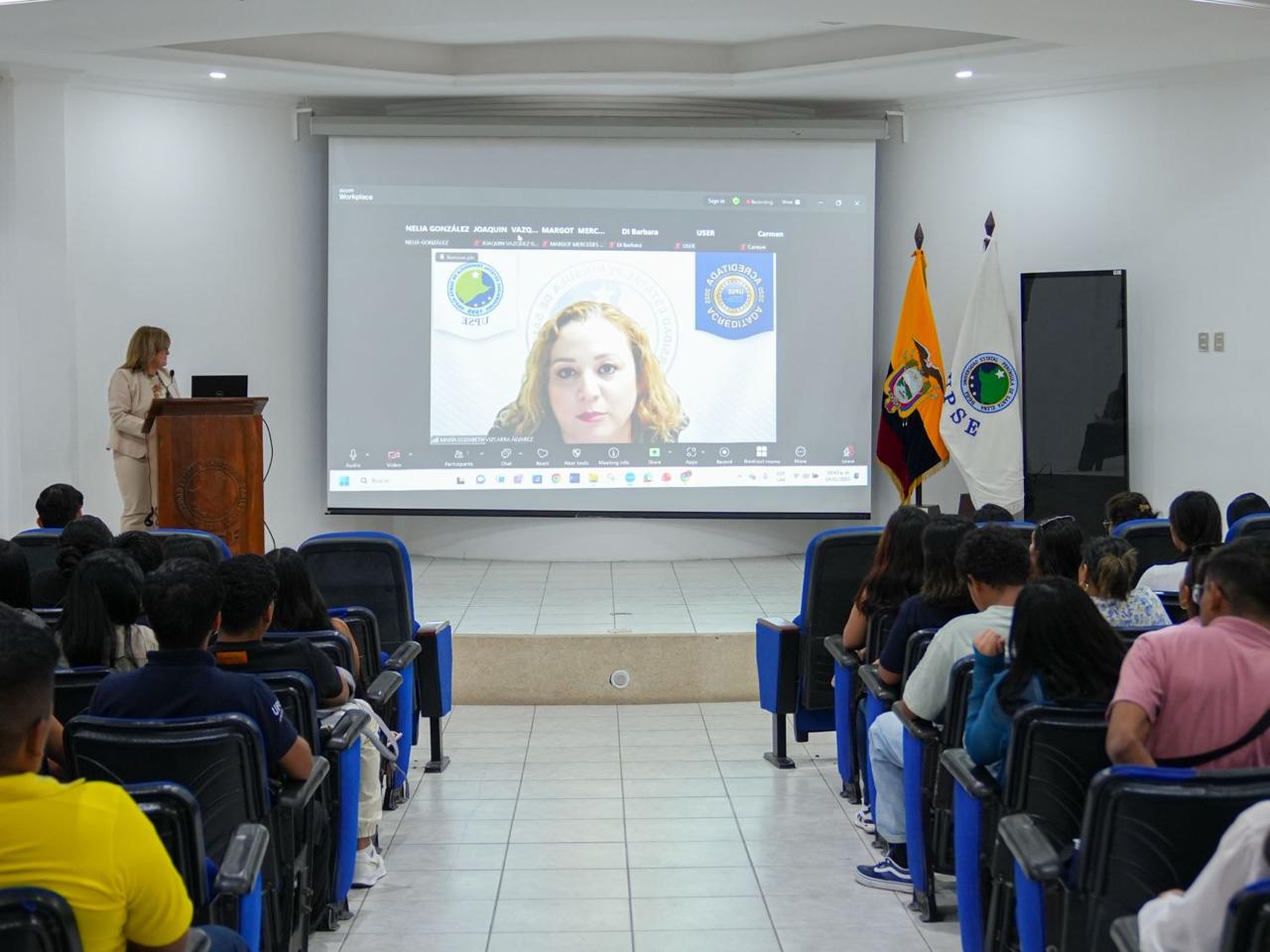 Conferencia ante auditorio en UPSE, con panel internacional en pantalla